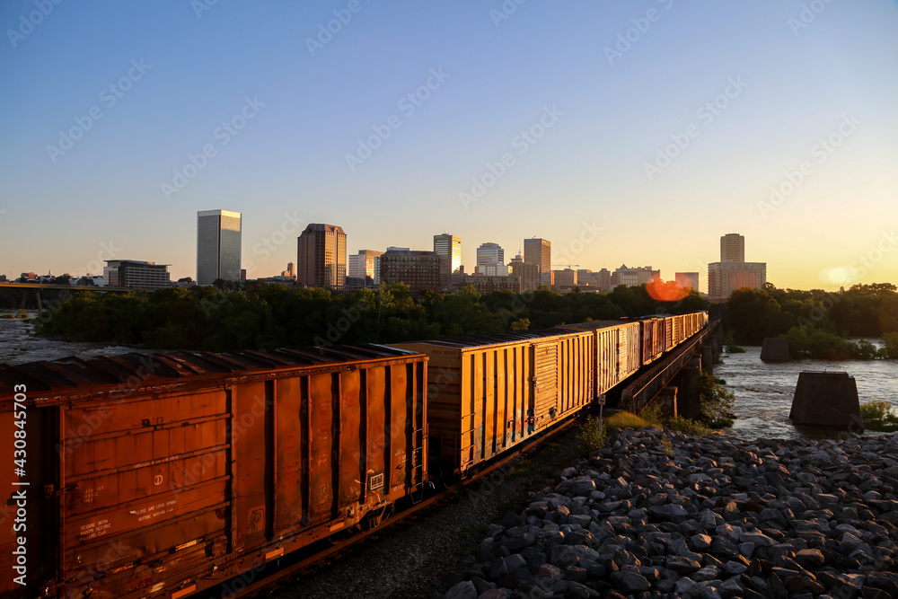 Fototapeta premium Train crossing bridge over the James River on the way to Richmond, Virginia at Sunrise.
