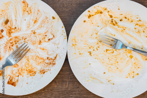 dirty plates after eating. filthy Cutlery. forks on a plate. messy dishes after eating.