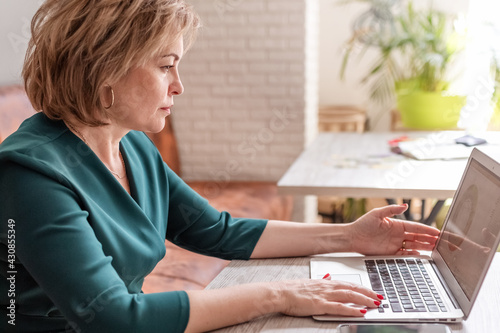 An adult female astrologer conducts an online consultation in the bright interior of the cafe. the concept of remote work and psychological assistance