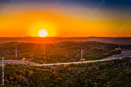 sunset over texas hill country with power lines