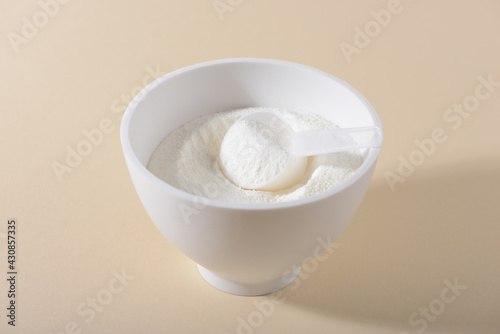 Collagen powder on beige background.