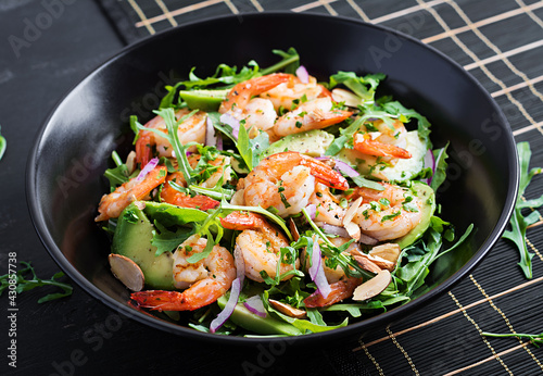 Salad of prawns. Salad of shrimps, arugula, avocado slice, red onion and almond nuts. Healthy concept.