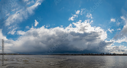 Panoramic landscape  a thundercloud over the Kama River in the city of Perm  gray storm clouds cover the blue sky.