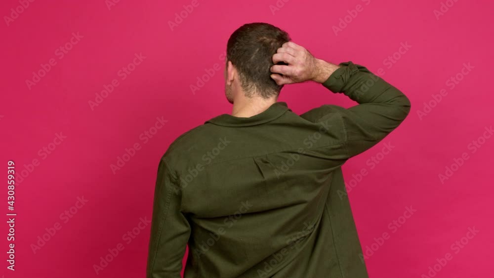 Brazilian handsome man on back position looking back while scratching head over isolated background Brazilian handsome man on back position looking back while scratching head over isolated background