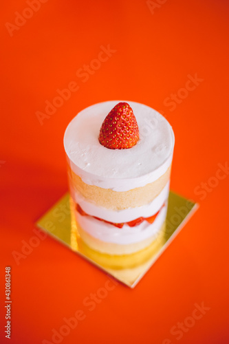 strawberry shortcake with whipped cream and fresh berries on red background