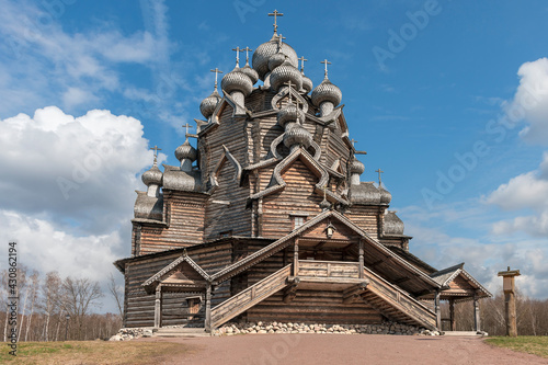 Old historic wooden church in the suburbs of the Russian city of St. Petersburg against the background of a blue cloudy sky