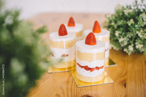 Strawberry shortcakes with whipped cream and fresh berries on wooden table