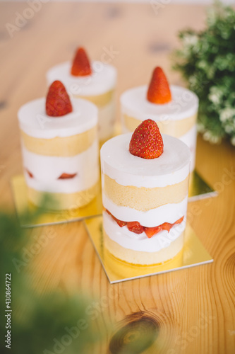 Strawberry shortcakes with whipped cream and fresh berries on wooden table