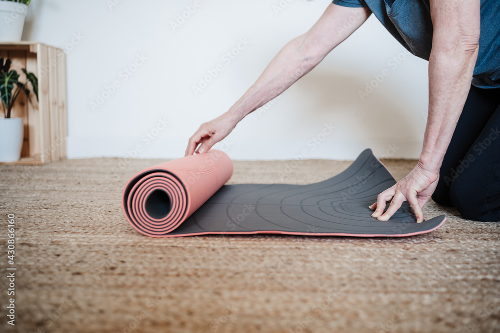 mature caucasian senior woman ready to practice yoga at home. Holding yoga mat. Healthy lifestyle