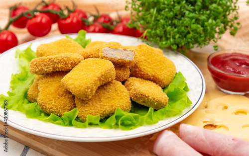 Chicken nuggets with ham and cheese on a plate. Cordon bleu. Appetizer.
