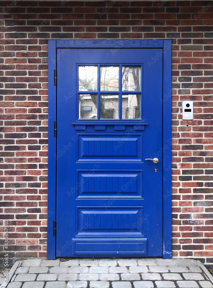 Fototapeta premium Beautiful blue door in a brick wall