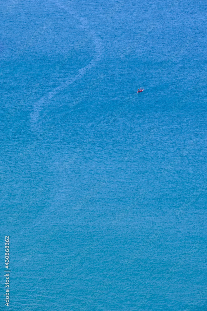 A canoe on the clean blue water of Trebarwith Strand.