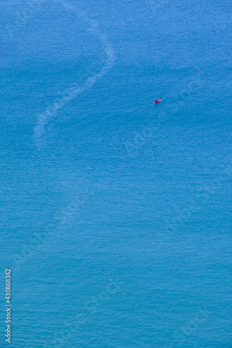 A canoe on the clean blue water of Trebarwith Strand.