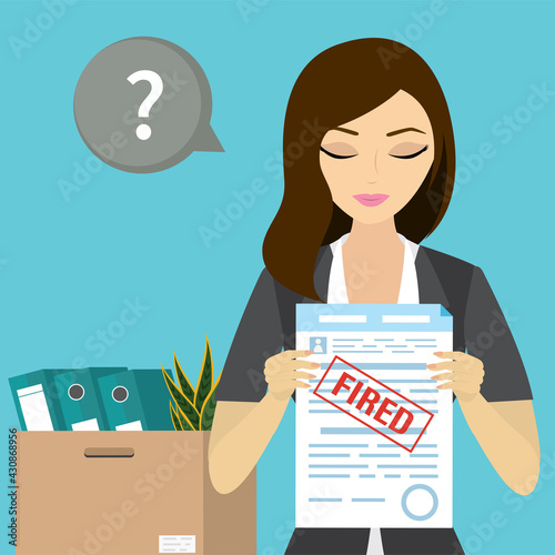 Female employee holding paper with red stamp - fired. Staff cuts, economic crisis. Problem of unemployment. Box with things on background.