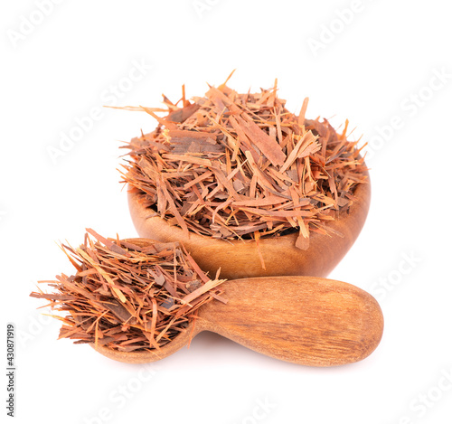 Lapacho herbal tea in wooden bowl, isolated on white background. Natural Taheeboo dry tea. Pau d'arco herb. Tabebuia heptophylla. photo