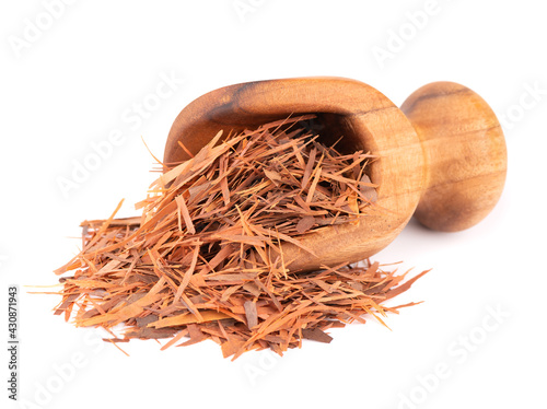 Lapacho herbal tea in wooden scoop, isolated on white background. Natural Taheeboo dry tea. Pau d'arco herb. Tabebuia heptophylla. photo