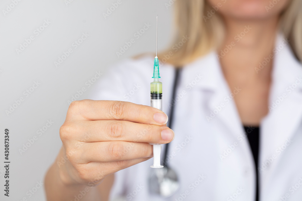 Young nurse or doctor holding syringe with new vaccine. Close-up of a vaccine medical syringe. Young nurse or doctor holding syringe with new vaccine. Close-up of a vaccine medical syringe.