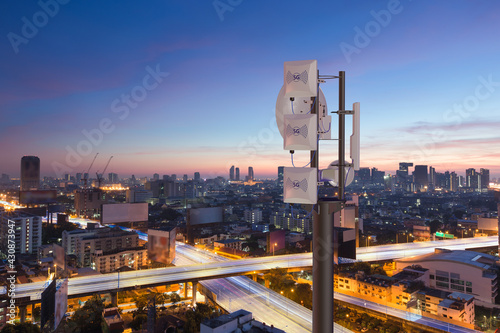Telecommunication tower with 5G cellular network antenna on night city background