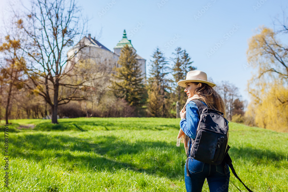 Fototapeta premium Tourist walking in Olesko Castle garden. Ancient architecture landmarks in Western Ukraine. Traveling