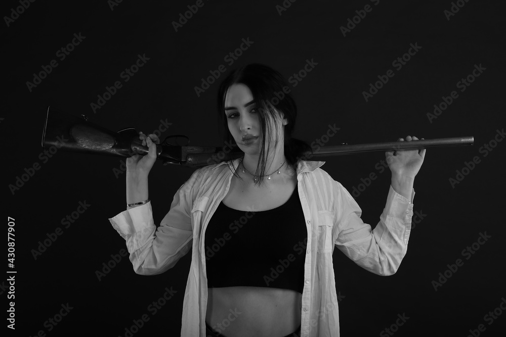 Black and white portrait of a brunette woman with shotgun Black and white portrait of a brunette woman with shotgun