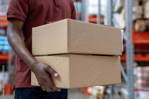 Fotografia Black mover carrying cardboard boxes