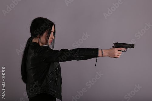 Brunette woman with a gun in her hand