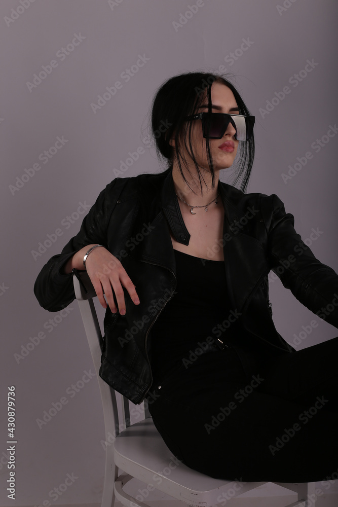 Young brunette woman with sunglasses on grey background Young brunette woman with sunglasses on grey background