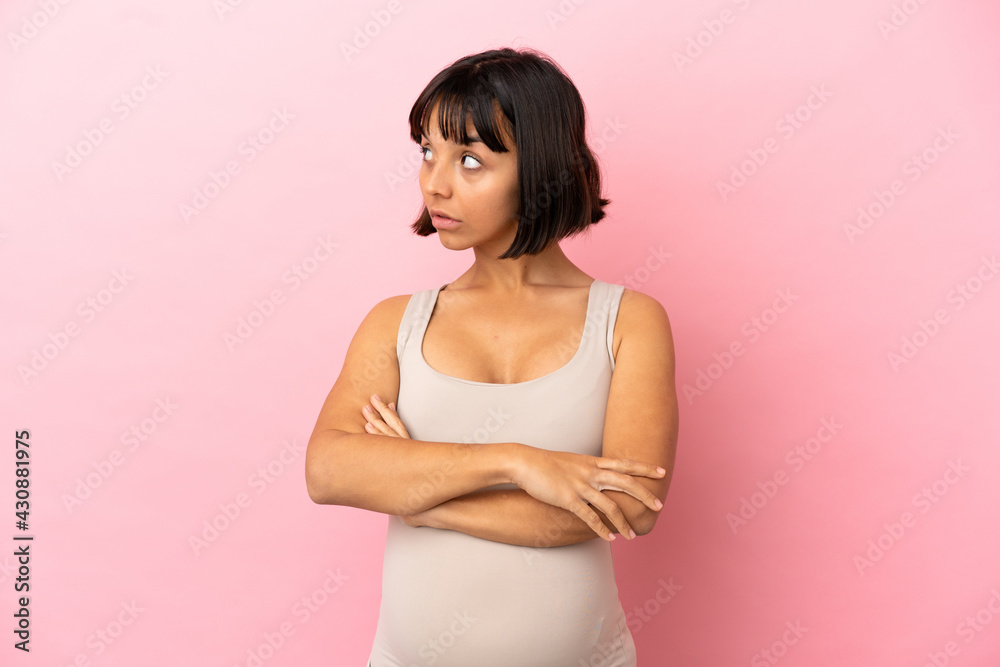 Young pregnant woman over isolated pink background keeping the arms crossed Young pregnant woman over isolated pink background keeping the arms crossed