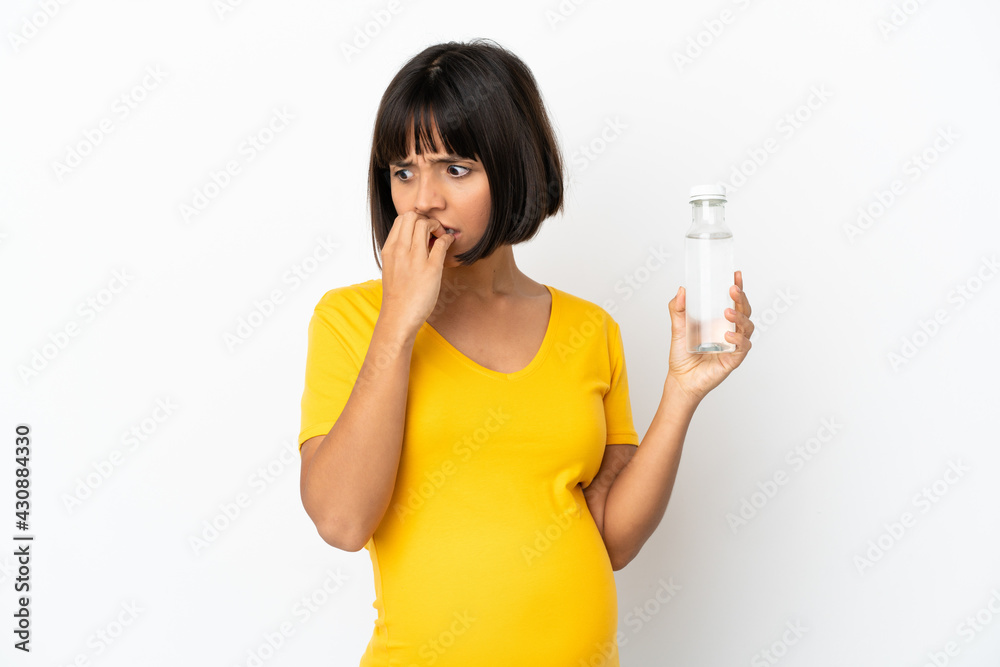 Young pregnant woman holding a bottle of water isolated on white background having doubts Young pregnant woman holding a bottle of water isolated on white background having doubts