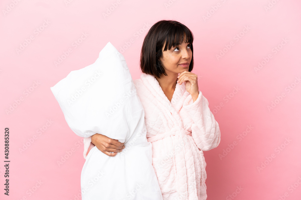 Pregnant woman in pajamas isolated on pink background and looking up Pregnant woman in pajamas isolated on pink background and looking up