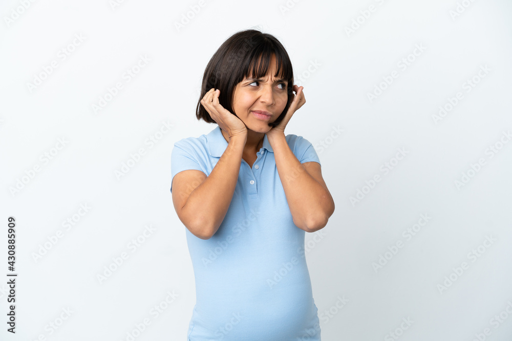 Pregnant woman over isolated white background frustrated and covering ears Pregnant woman over isolated white background frustrated and covering ears
