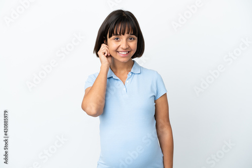 Pregnant woman over isolated white background laughing