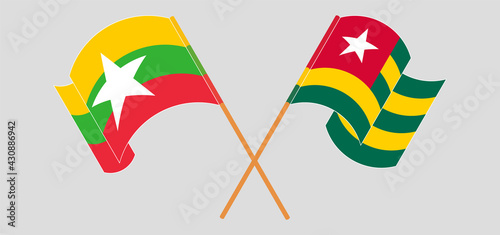 Crossed and waving flags of Myanmar and Togo