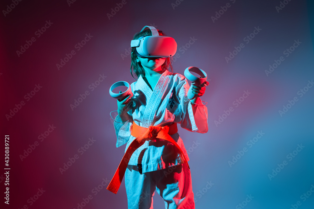 Young caucasian girl in karate uniform playing video games with virtual reality Young caucasian girl in karate uniform playing video games with virtual reality