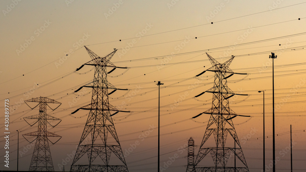 high voltage electric towers during sunset.