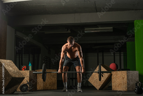 Fit strong shirtless athlete doing squats. Hardcore Cross-fit workout concept.