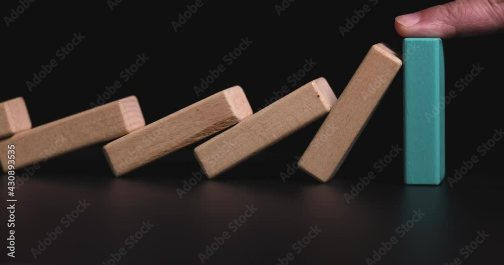 4K Video slow motion close up hand stop domino effect. business concept of try to stop the domino effect .