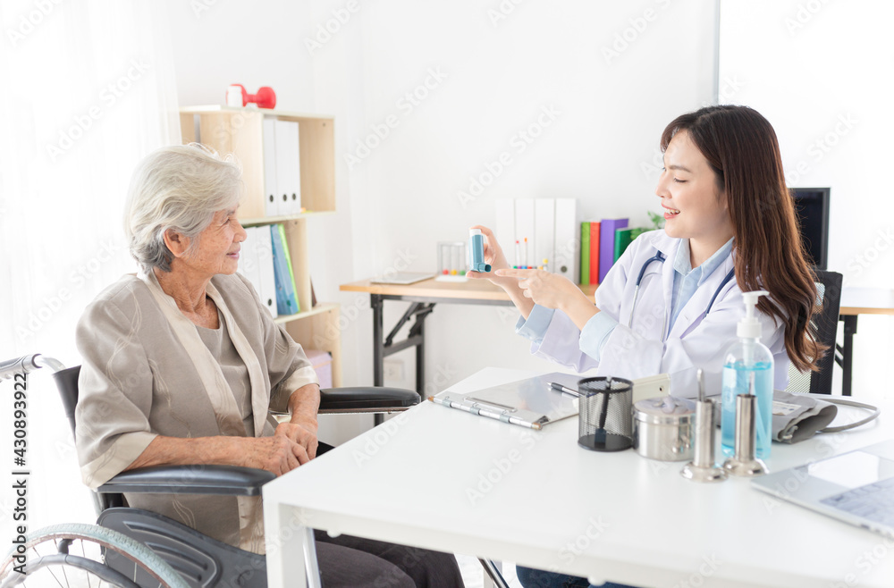 asian female doctor explaining about how to use inhaler medicine  with old patient in asthma clinic, elderly disease treatment, she holding inhaler medicine with hand