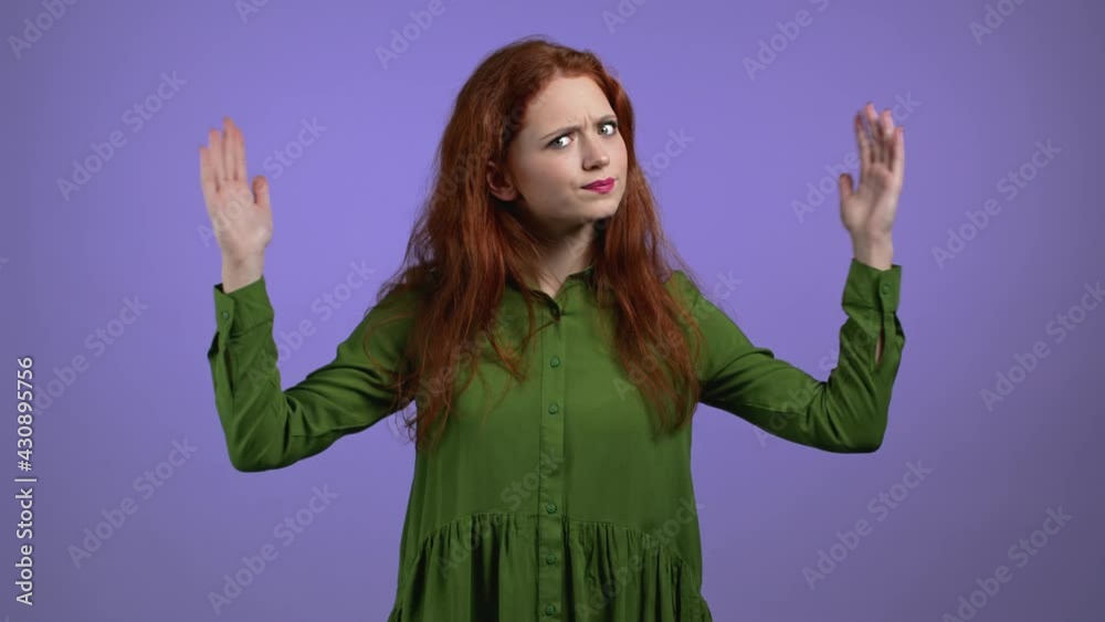 Young woman showing invisible abstract big subject or object. Large concept. Violet studio background Young woman showing invisible abstract big subject or object. Large concept. Violet studio background