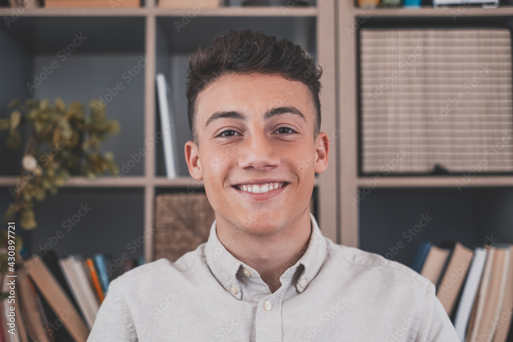Fototapeta premium Portrait of one young and happy cheerful man smiling looking at the camera having fun. Headshot of male person working at home in the office..