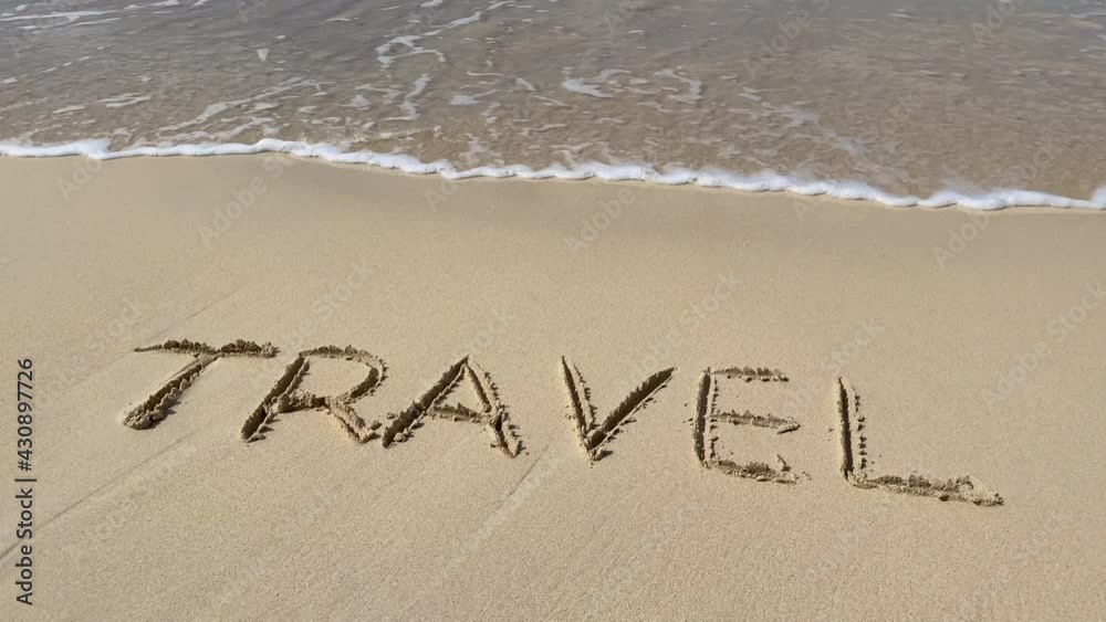 Sea wave makes an inscription on the sand Travel in slow motion on the beach. Concept of vacation and adventure