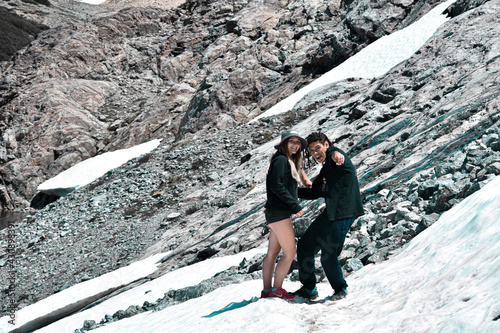 pareja joven divirtiendose en la nieve sobre la montaña photo