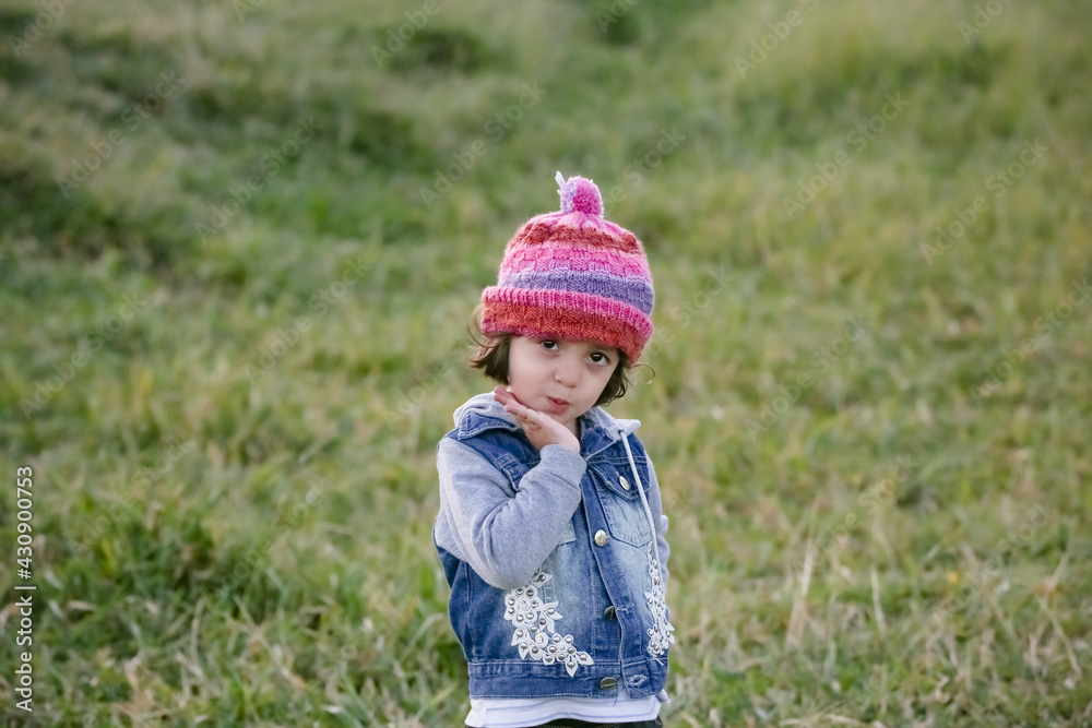Criança na montanha com touca rosa olhando e fazendo poses para fotos. Criança na montanha com touca rosa olhando e fazendo poses para fotos.