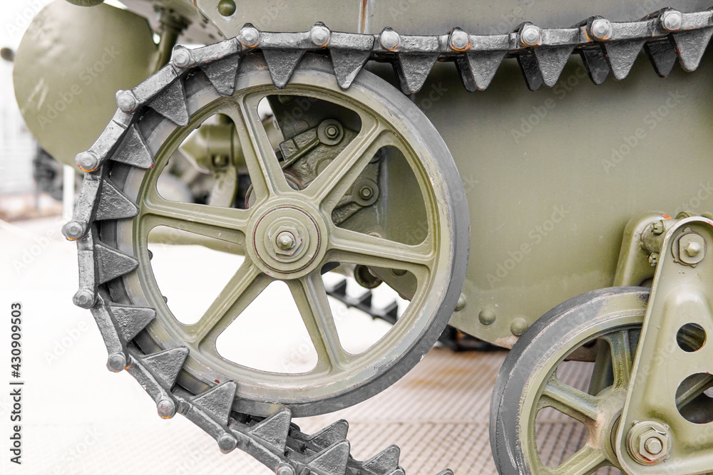 Fototapeta premium Tank of the Second World War. Track armor close-up. Black track link and large rubberized rollers. Tank chassis. The tank stands on a pedestal.Russia, May 9, 2021. Detail of a tracked tank close-up.