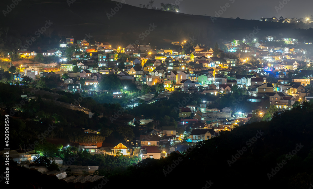 Obraz premium Night scene in the valley bright houses with colorful lights makes the night scene in the countryside more vibrant in the Da Lat plateau, Vietnam