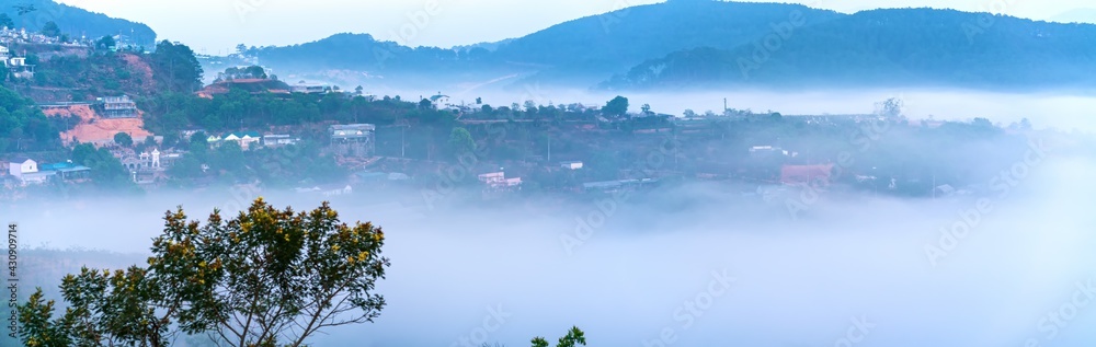 Obraz premium The morning scenery on the hillside in the misty highlands below the beautiful valley