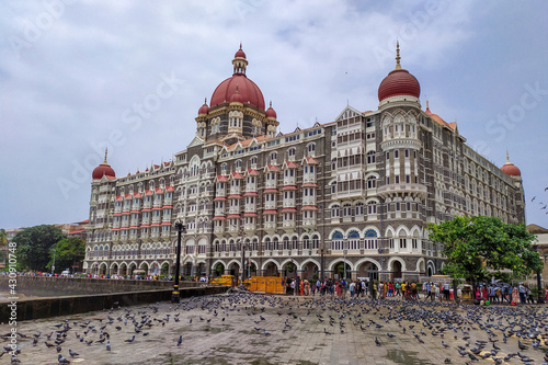 Foto The Taj Mahal Palace Hotel in Mumbai, India along with visitor and pigeon