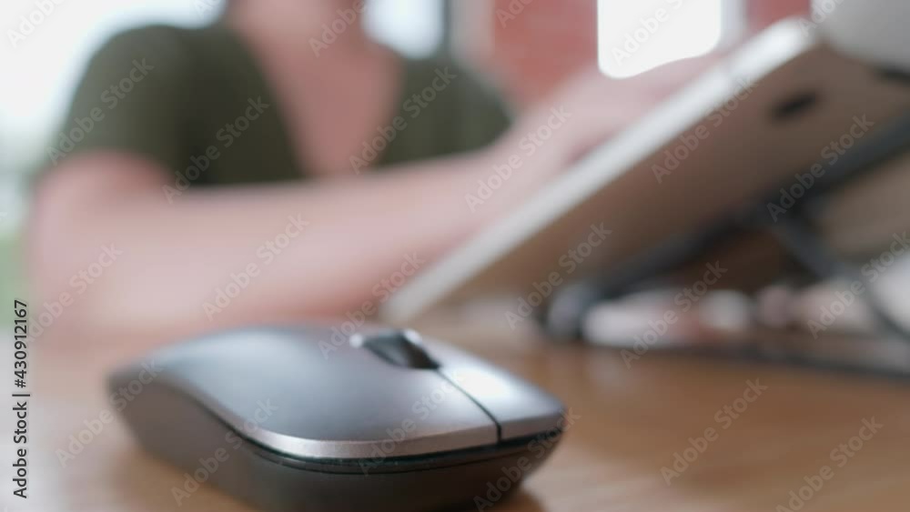 Female hands of business freelance Asian woman click mouse button and move cursor switch typing keyboard while using application software working in notebook on desk at home office, close up view