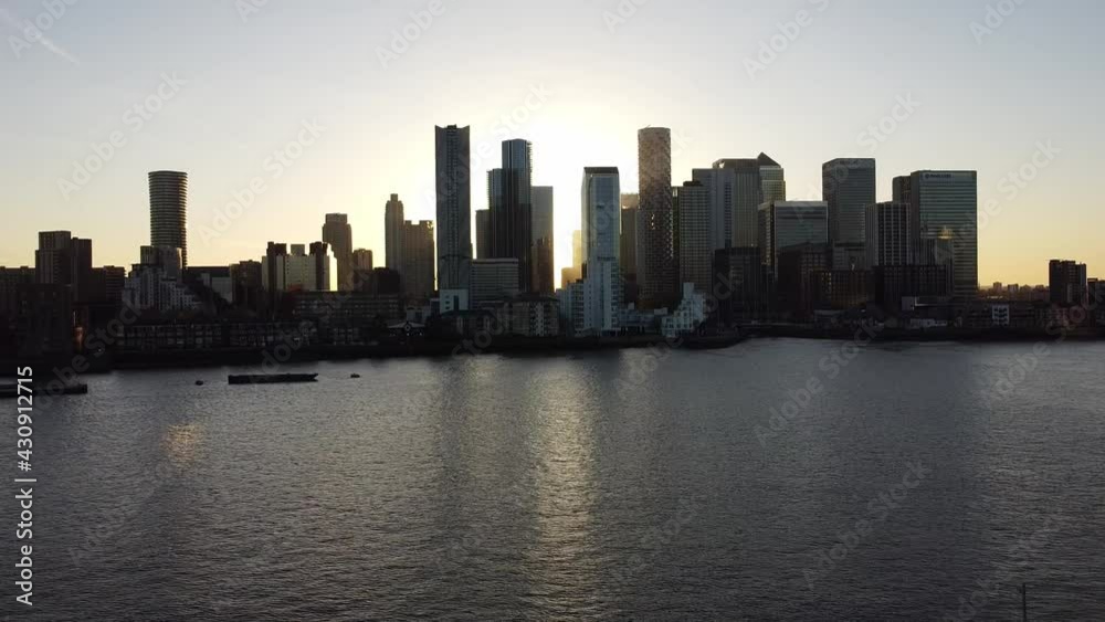 Epic Silhouette of skyscraper in Canary Wharf District while golden sunset. Aerial drone shot. London,United Kingdom. Epic Silhouette of skyscraper in Canary Wharf District while golden sunset. Aerial drone shot. London,United Kingdom.