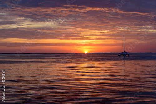 Sailing and yachting at sea. Boat on water at sunset. Sailboats with sails. Ocean water. © Volodymyr